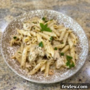 Delicious Creamy Pesto Chicken Pasta dish garnished with fresh basil leaves, ready to be served