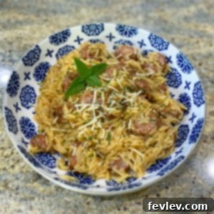 A delicious skillet of Smoked Sausage and Orzo, garnished and ready to serve
