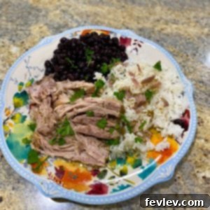 Delicious Cuban Pork slow cooking in a crockpot, ready to be shredded with rich mojo sauce