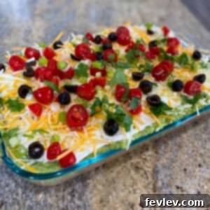 Delicious 5-Layer Taco Dip topped with fresh ingredients, ready to be served with tortilla chips