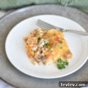 Delicious Sausage Casserole with Cauliflower Rice, topped with melted cheddar cheese