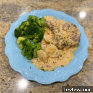 Delicious Slow Cooker Cheesy Pork Chops and Potatoes served in a bowl, garnished with green onions