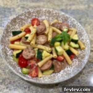 A vibrant bowl of One-Pot Chicken and Zucchini Pasta, garnished with fresh basil and Parmesan cheese