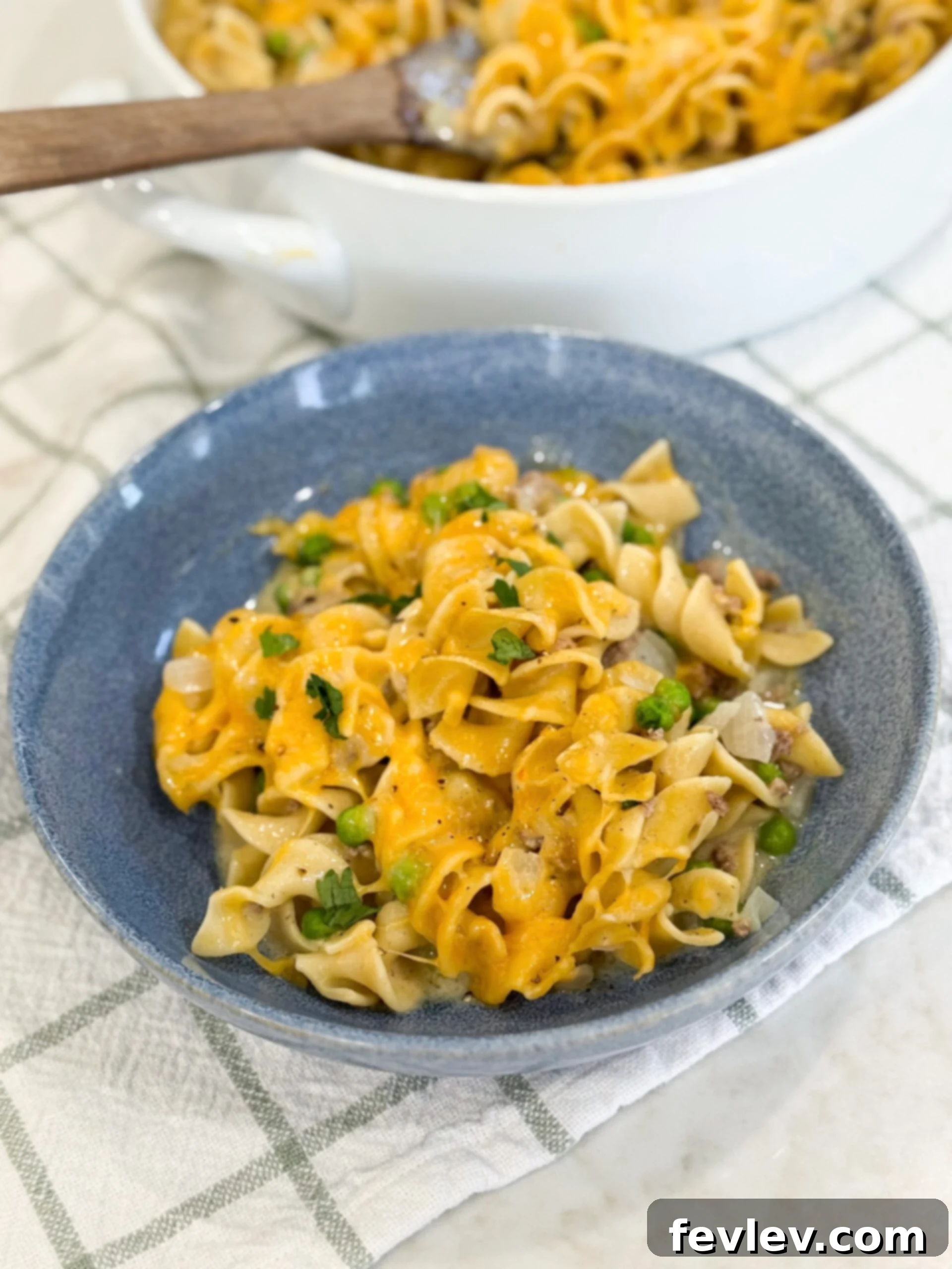 Ground beef stroganoff casserole in a baking dish topped with melted cheese, ready to be served