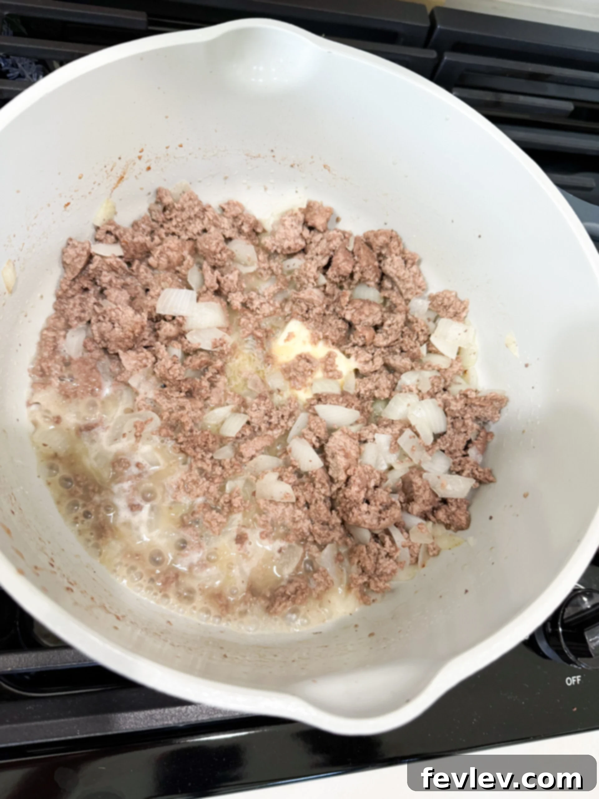 Ground beef and onions browning in a large pot on the stovetop