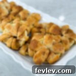 Golden baked apple crescent donuts dusted with powdered sugar, a quick and delightful breakfast or dessert.