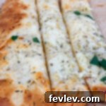 Cheesy garlic bread made with crescent dough, baked to golden perfection, ideal as a side or snack.