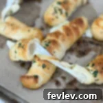 Golden brown mozzarella-stuffed garlic breadsticks, oozing with cheesy goodness and infused with savory garlic flavor.