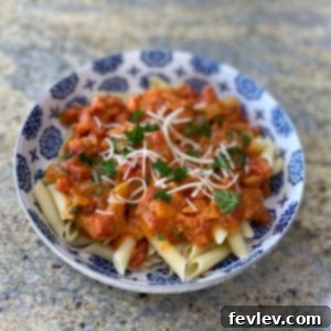 Delicious creamy tomato and spinach pasta, garnished with fresh herbs, in a large skillet.