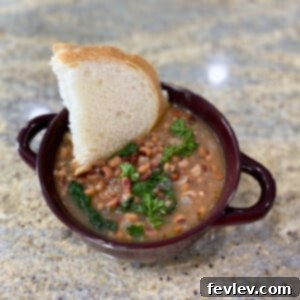 A bowl of savory black eyed peas and spinach, garnished with fresh herbs, ready to be served.