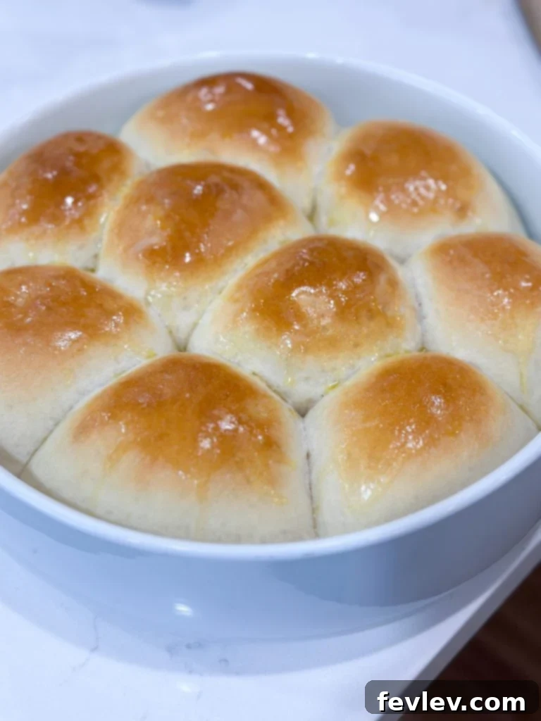 Stack of fluffy, easy homemade one-hour dinner rolls, brushed with butter.