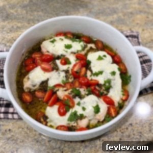 Delicious oven-baked pesto chicken with melted mozzarella and fresh cherry tomatoes.