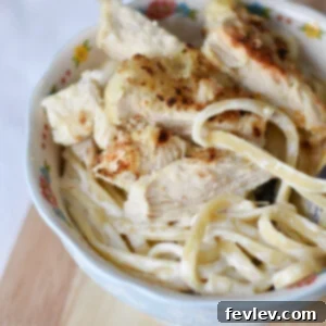 A vibrant plate of Lemon Chicken Pasta, featuring golden crispy panko-breaded chicken slices resting on a bed of creamy, zesty fettuccini, garnished with fresh parsley.