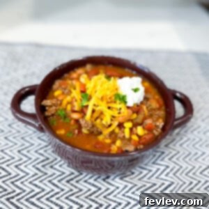A delicious bowl of slow cooker taco soup garnished with fresh cilantro and shredded cheese.