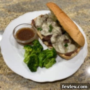 Mouth-watering Slow Cooker French Dip Sandwich with a side of savory au jus for dipping