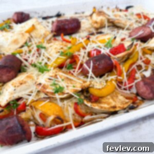 Golden brown kielbasa, pierogies, and roasted bell peppers with onions on a sheet pan, ready to serve.