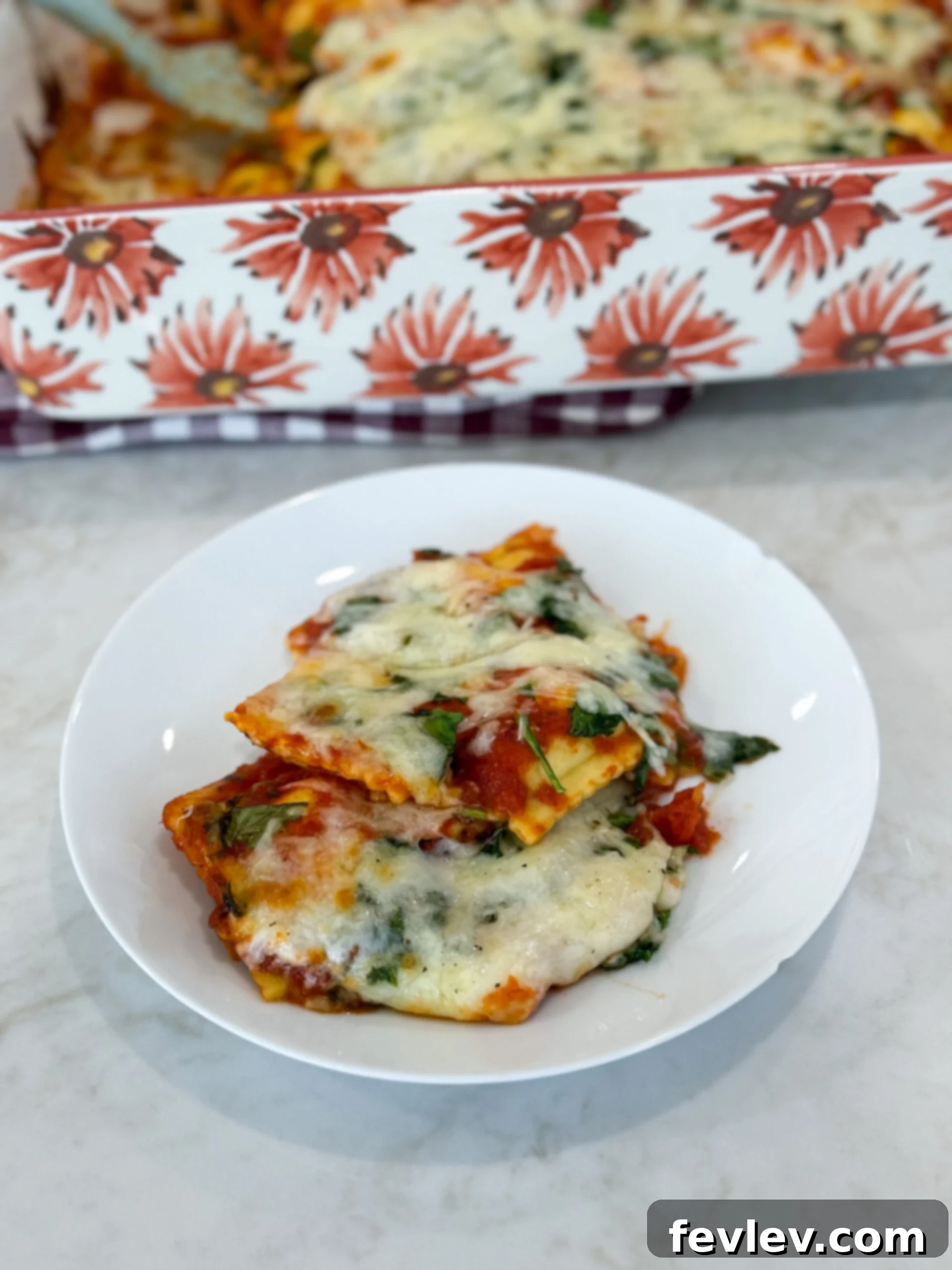Simple cheese ravioli bake on a plate topped with melted mozzarella and herbs, showcasing its delicious, comforting appeal.