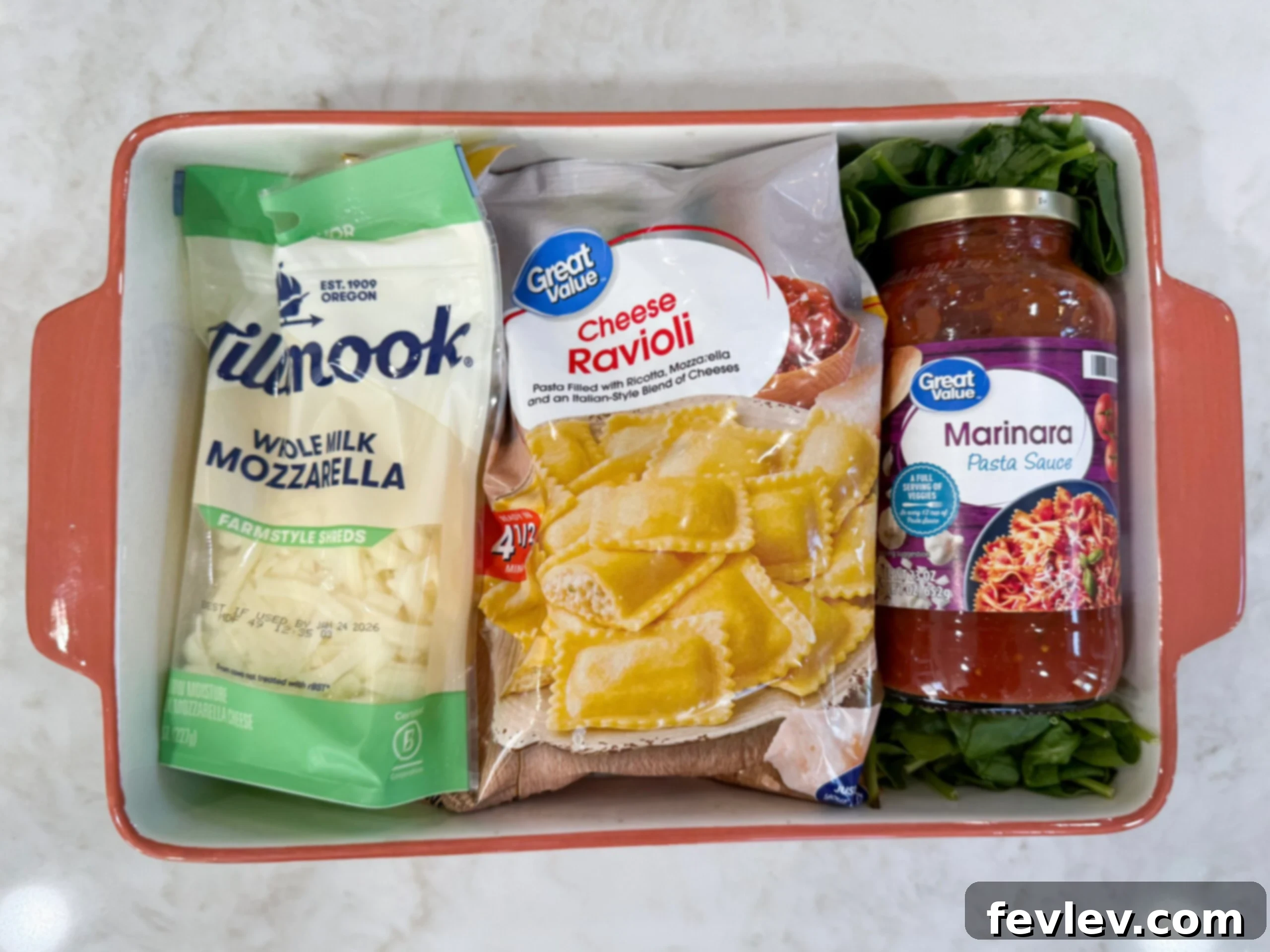 All the fresh ingredients for the simple cheese ravioli bake arranged in a casserole dish before assembly.