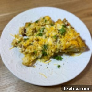 Hearty Tater Tot, Sausage, and Egg Casserole cooking in a slow cooker, garnished with fresh herbs.