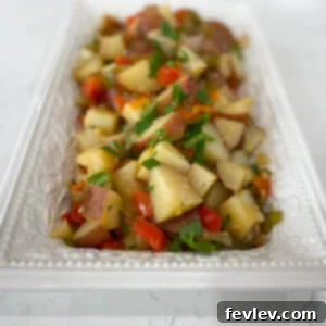 A close-up shot of perfectly cooked Crockpot Breakfast Potatoes, garnished with fresh herbs.