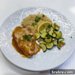 Perfectly seared brown sugar glazed pork chops on a plate with sides