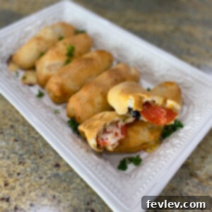 Delicious golden brown homemade pizza rolls fresh out of the oven, ready to be served with marinara sauce.