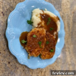 Deliciously crispy Parmesan Crusted Pork Chops, ready in just 20 minutes, served with mashed potatoes.