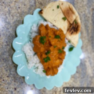 Delicious 20-Minute Butter Chicken served with fluffy rice and warm naan bread, garnished with fresh cilantro