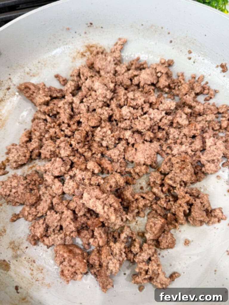 Epic Loaded Baked Queso 3 Brown ground beef in a skillet for the loaded queso