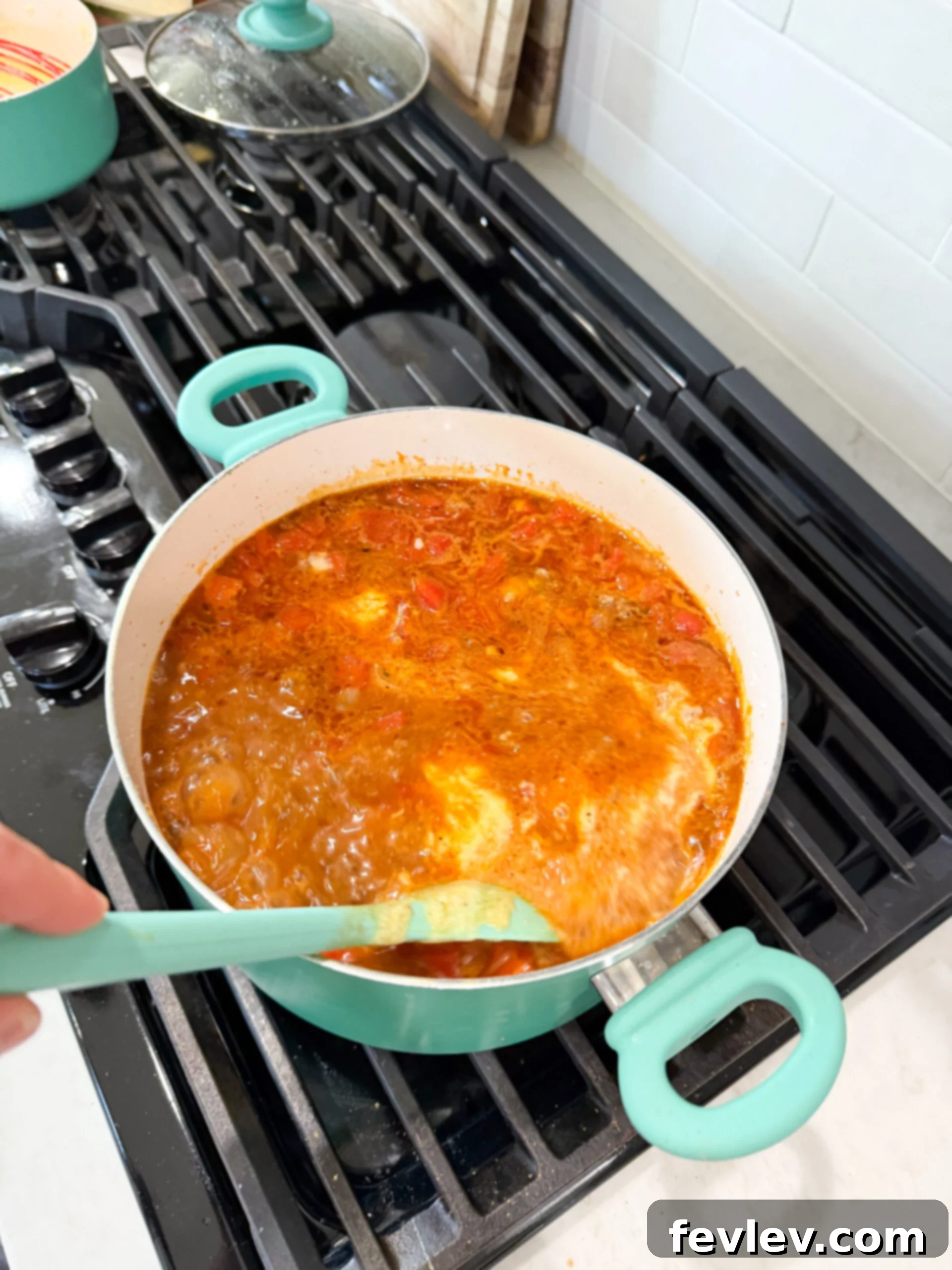 Golden Queso Chili 9 Homemade queso sauce being prepared in a small saucepan, showing melted cheese and smooth consistency