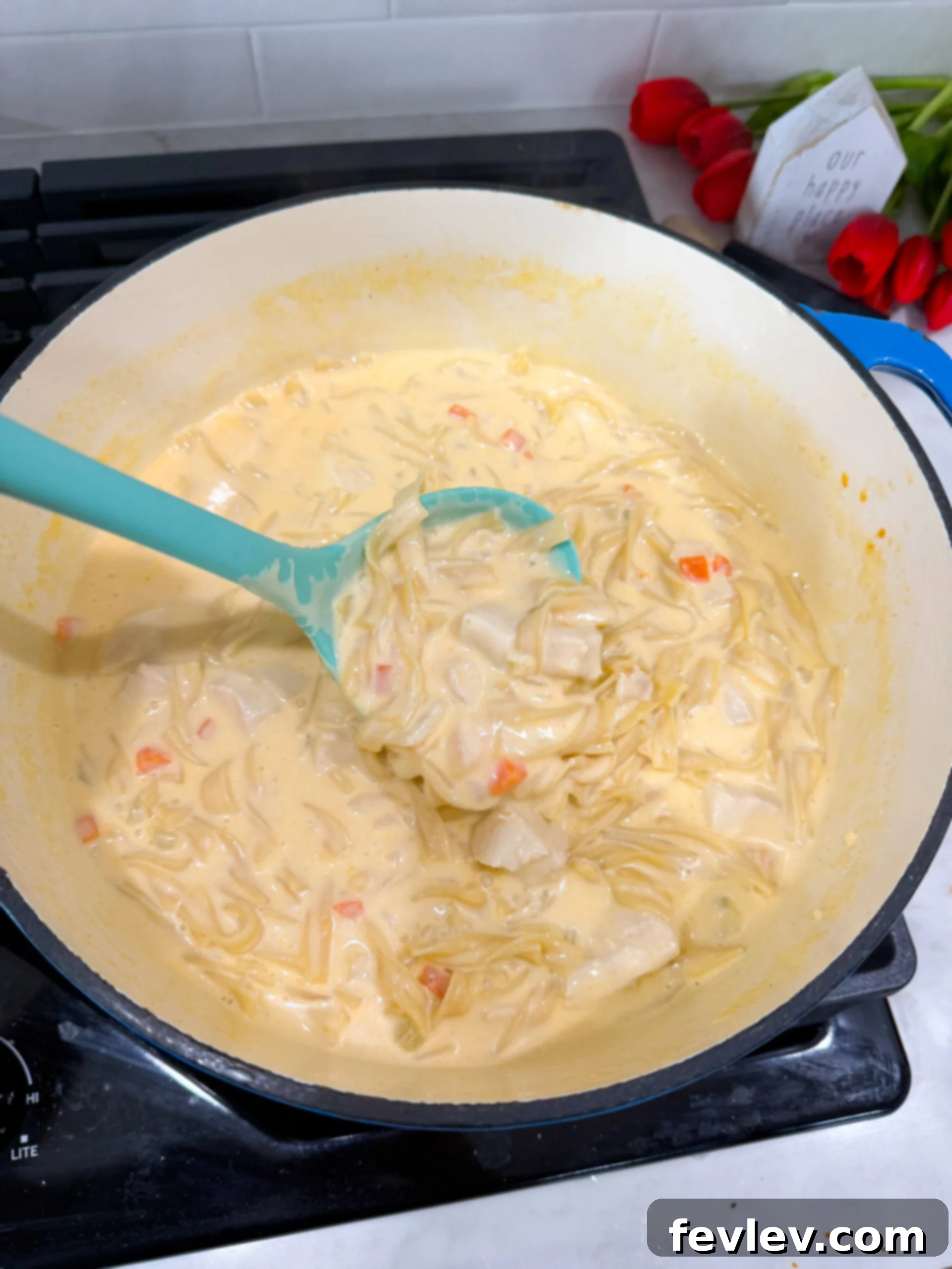 Chicken simmering in broth with vegetables