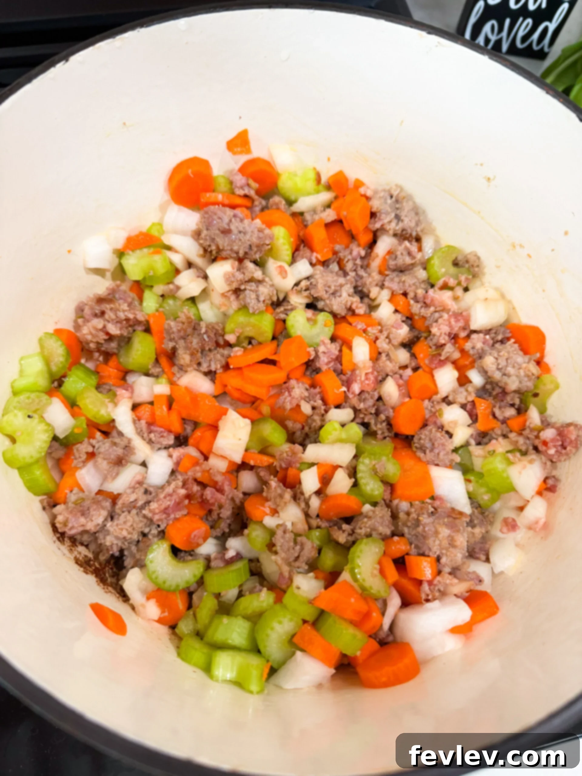 Adding carrots, onions, and celery to the pot.