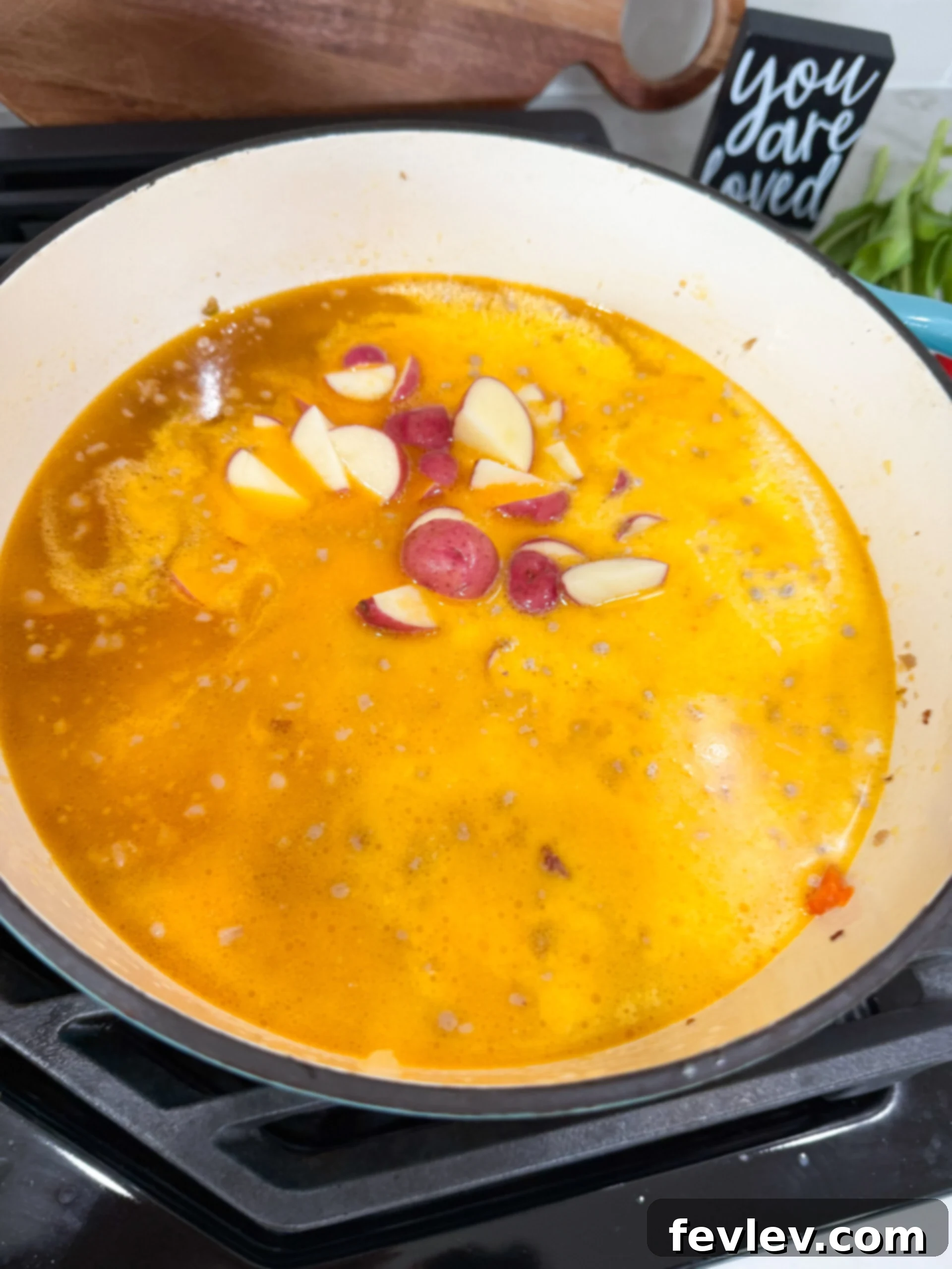 Adding potatoes to the soup pot.