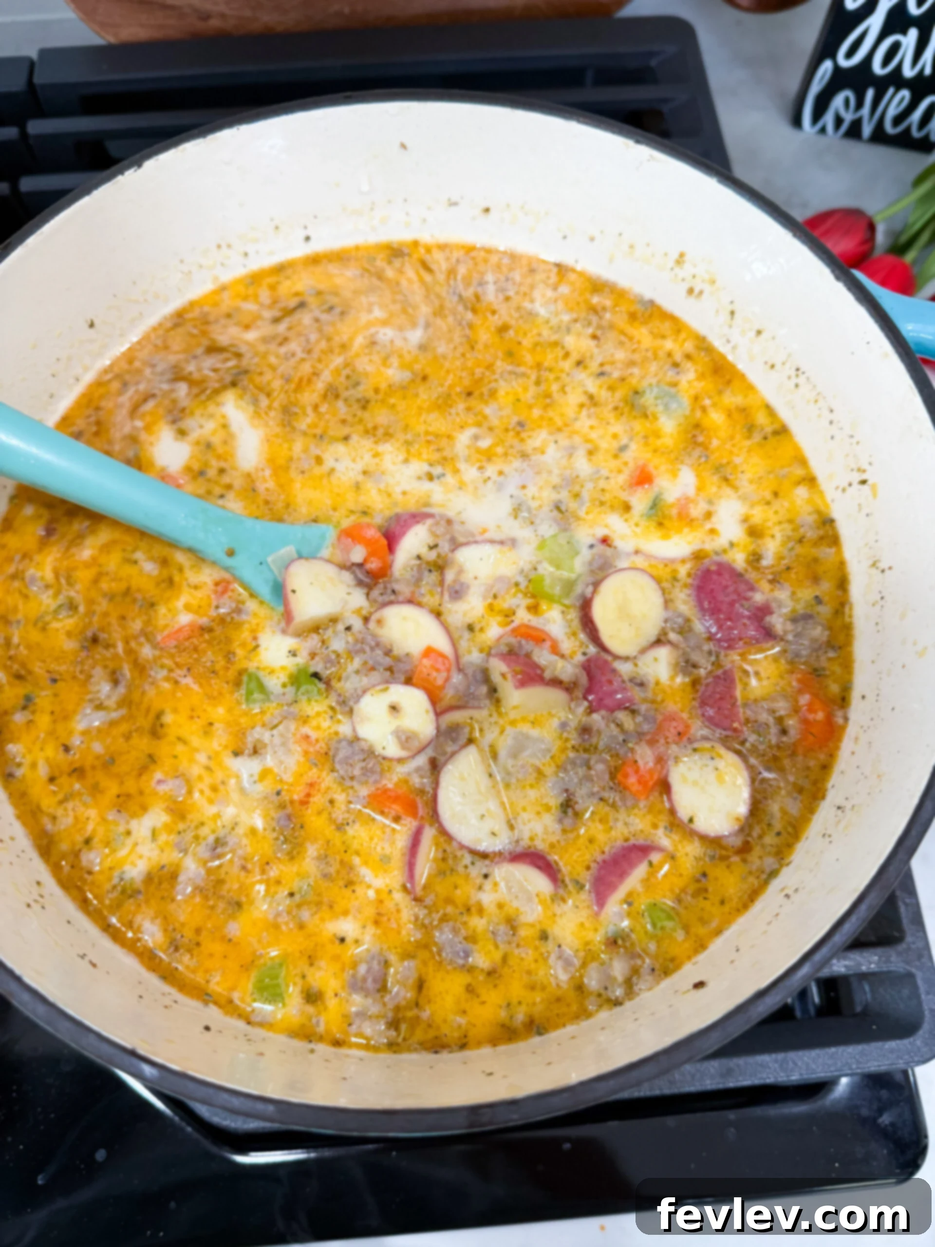 Soup simmering with potatoes, cooking until tender.