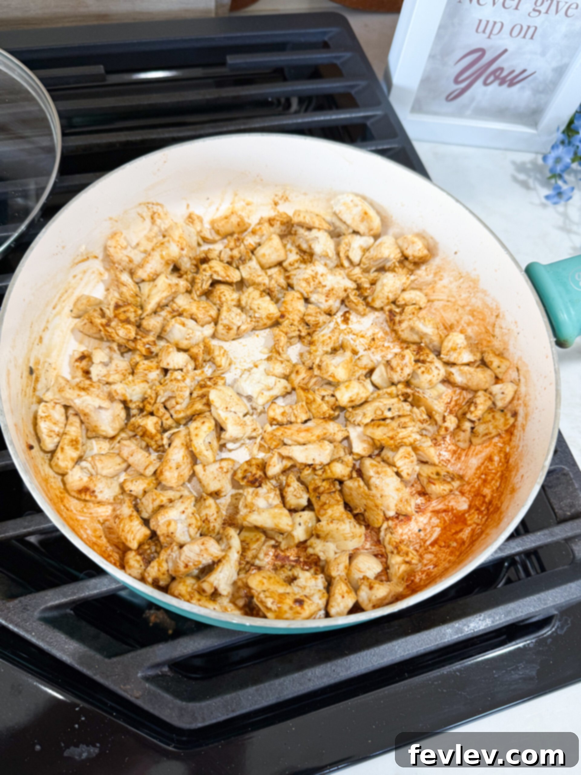 Spices added to the cooked chicken in the skillet
